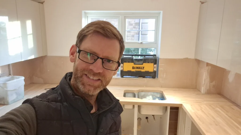 A selfie of Matthew Day during a kitchen installation with a solid oak worktop